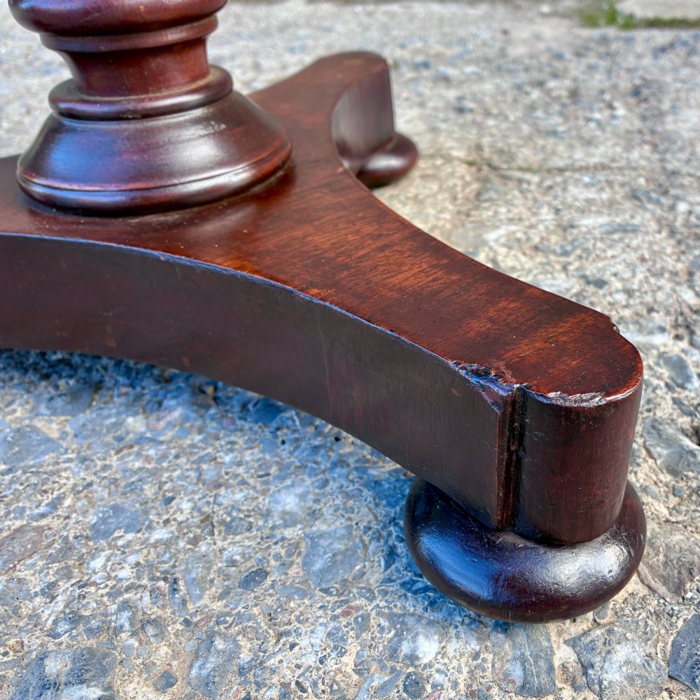 A Victorian mahogany wine table featuring a circular top supported by a turned central pedestal column resting on a tripod base. View VII