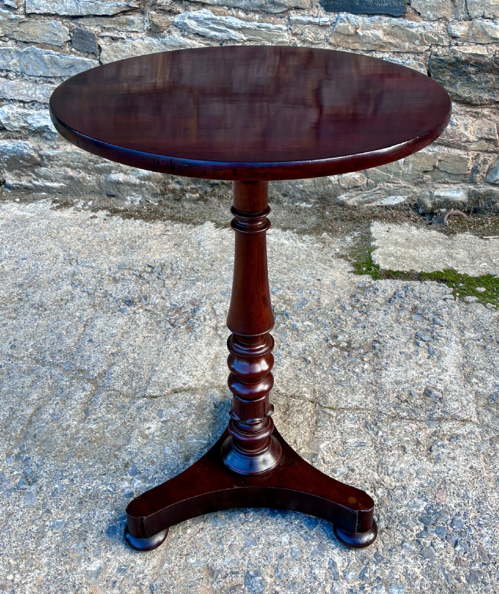 A Victorian mahogany wine table featuring a circular top supported by a turned central pedestal column resting on a tripod base. View VIII