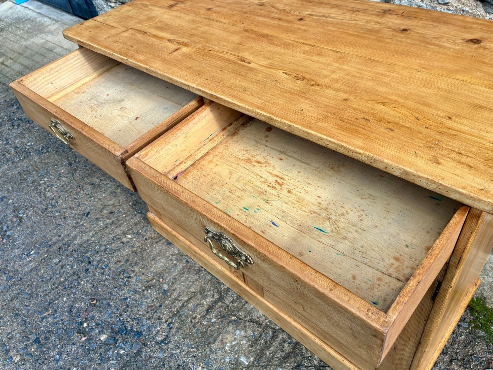 A nineteenth-century stripped pine sideboard featuring two upper drawers with ornate brass handles above two panelled cupboard doors on a solid plinth base. View IX