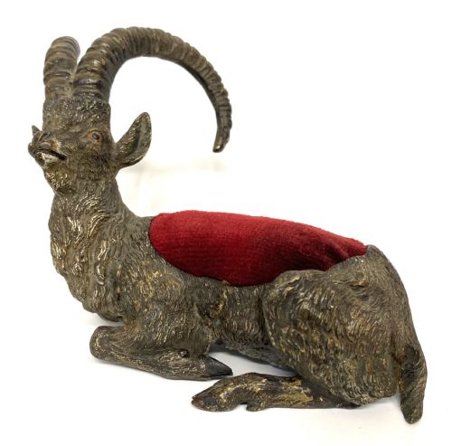 fig 1. An antique Austrian cold-painted bronze figurine of a recumbent ibex with long curved horns and an integrated red velvet pin cushion set into its back.