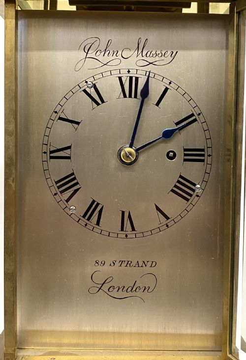 fig 2. An antique brass four-glass library clock featuring an engraved silvered dial with Roman numerals and glass side panels.