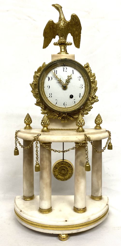 fig 1. An antique Neoclassical portico clock crafted from white alabaster columns and gilt bronze accents, topped with an eagle finial.