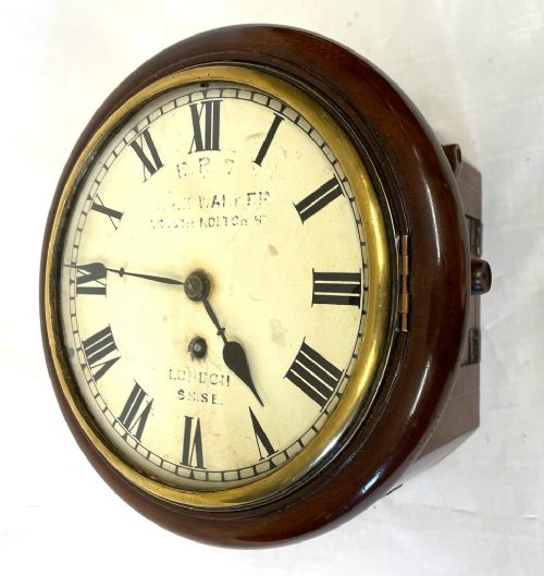 fig 1. A Victorian circular mahogany fusee wall clock featuring an off-white dial with black Roman numerals and a brass bezel.
