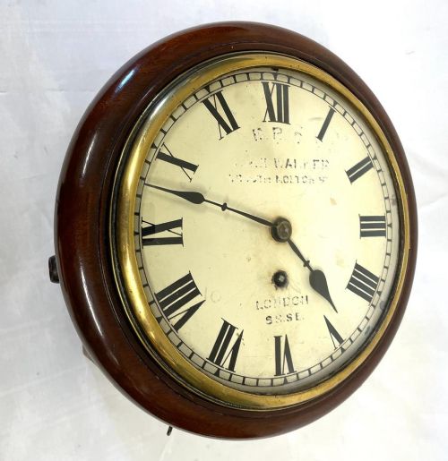 fig 2. A Victorian circular mahogany fusee wall clock featuring an off-white dial with black Roman numerals and a brass bezel.