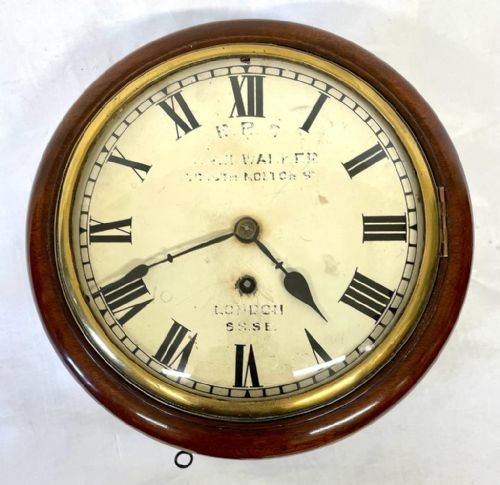 fig 3. A Victorian circular mahogany fusee wall clock featuring an off-white dial with black Roman numerals and a brass bezel.