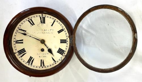 fig 4. A Victorian circular mahogany fusee wall clock featuring an off-white dial with black Roman numerals and a brass bezel.