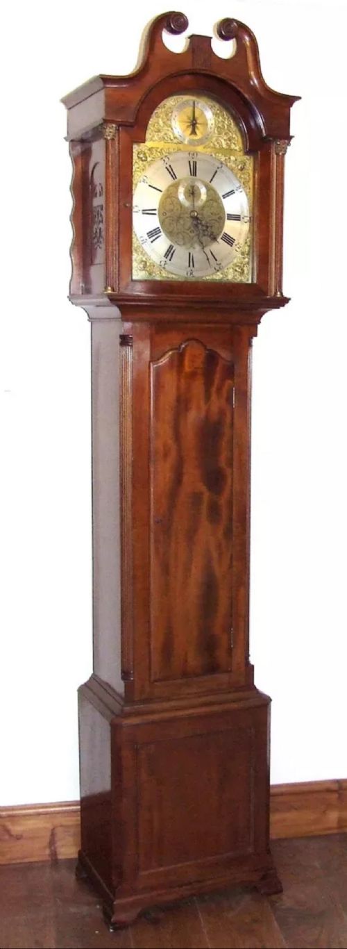 fig 1. A mahogany longcase grandfather clock featuring a swan-neck pediment, brass dial with Roman numerals, and a polished timber cabinet.