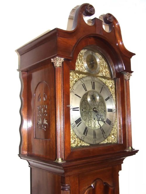 fig 5. A mahogany longcase grandfather clock featuring a swan-neck pediment, brass dial with Roman numerals, and a polished timber cabinet.