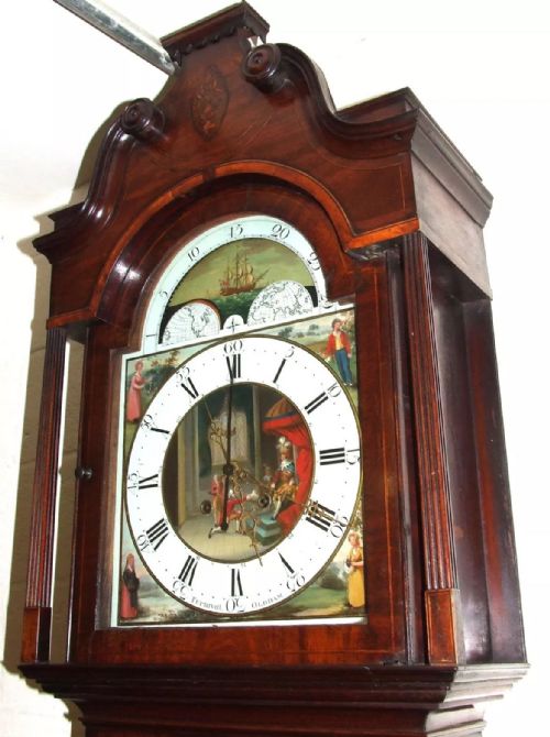 fig 1. An antique mahogany longcase grandfather clock featuring a painted arched dial with a moon phase indicator, swan neck pediment, and flame mahogany inlaid cabinet door.