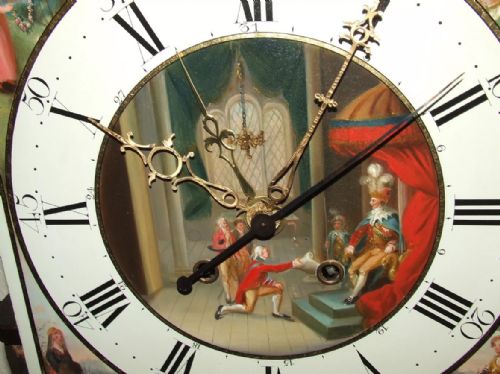 fig 2. An antique mahogany longcase grandfather clock featuring a painted arched dial with a moon phase indicator, swan neck pediment, and flame mahogany inlaid cabinet door.