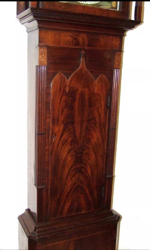 fig 6. An antique mahogany longcase grandfather clock featuring a painted arched dial with a moon phase indicator, swan neck pediment, and flame mahogany inlaid cabinet door.