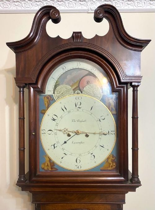 fig 3. A Georgian flame mahogany longcase clock featuring a swan-neck pediment, turned columns, and a painted dial with a rolling moon phase mechanism.