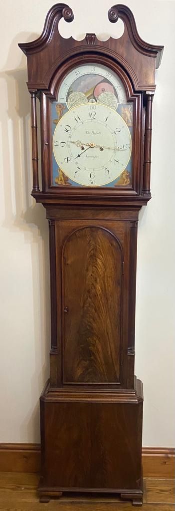 fig 5. A Georgian flame mahogany longcase clock featuring a swan-neck pediment, turned columns, and a painted dial with a rolling moon phase mechanism.