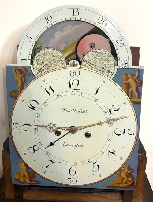fig 6. A Georgian flame mahogany longcase clock featuring a swan-neck pediment, turned columns, and a painted dial with a rolling moon phase mechanism.