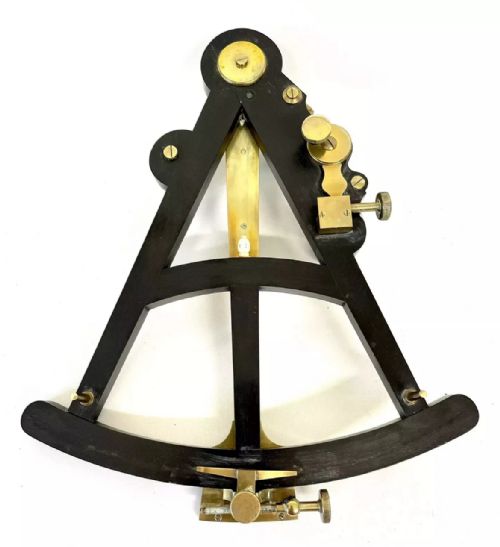 fig 3. An antique brass and ebony marine octant with an inlaid arc scale, set inside an open keystone-shaped mahogany carrying case with a paper maker label.