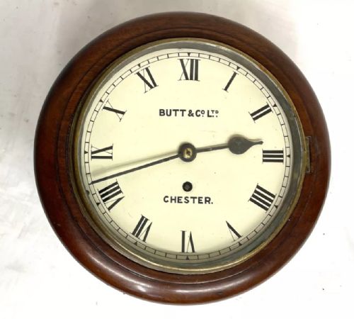 fig 1. A circular mahogany wall clock with an cream dial, black Roman numerals, steel spade hands, and a brass bezel inscribed with Butt and Co Ltd Chester.
