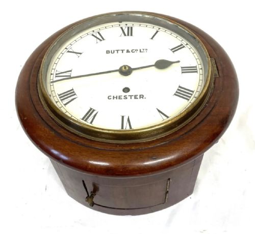 fig 3. A circular mahogany wall clock with an cream dial, black Roman numerals, steel spade hands, and a brass bezel inscribed with Butt and Co Ltd Chester.