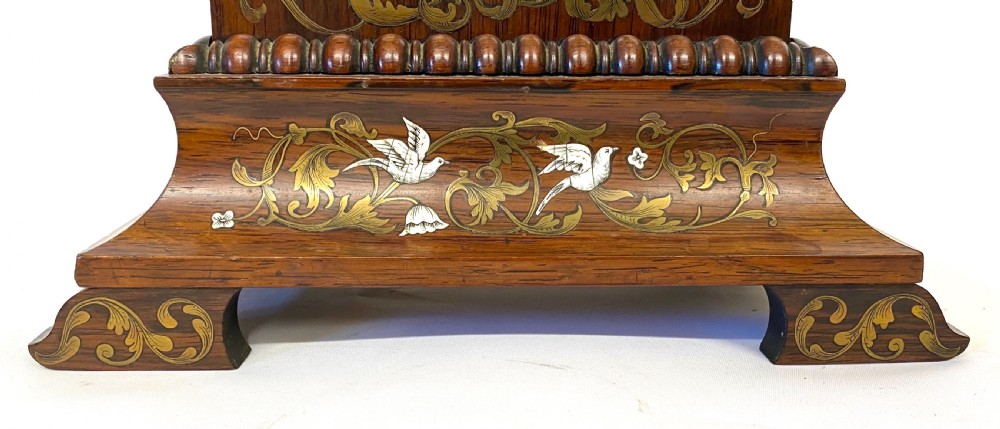 An antique French rosewood mantel clock featuring detailed brass foliage marquetry, bone cherub inlay, and a circular Roman numeral dial. View VII