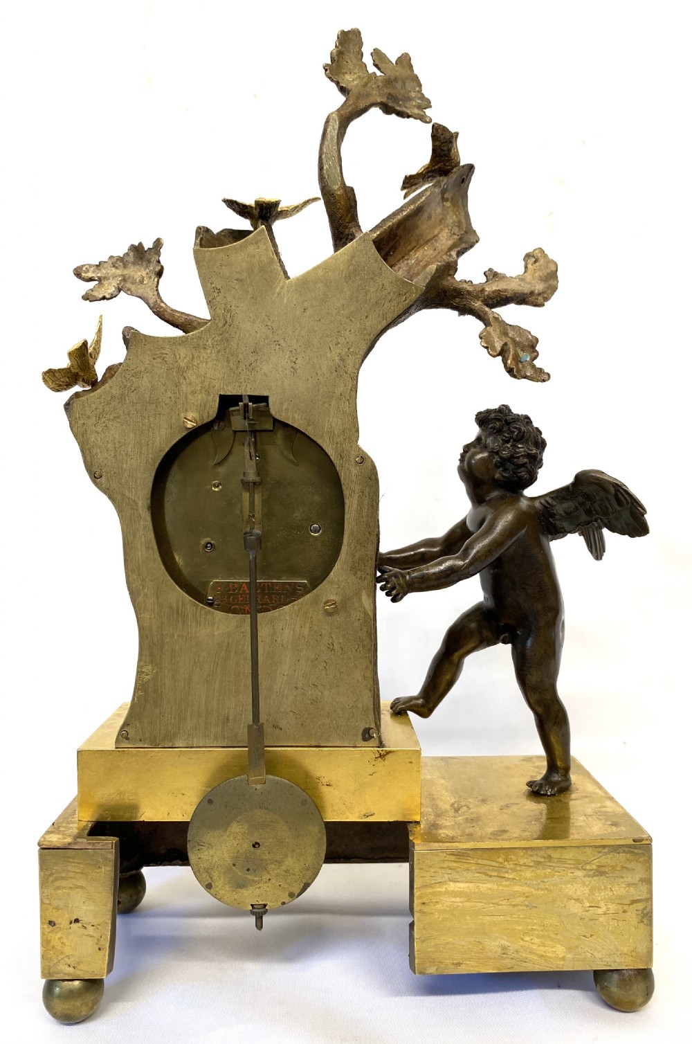 An antique gilt and patinated bronze mantel clock featuring a dark bronze cherub beside a tree stump clock housing topped with small birds. View IX