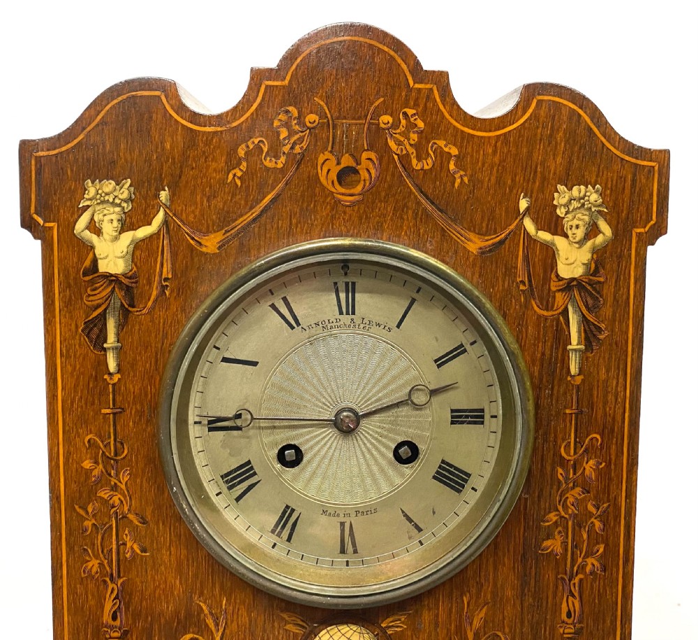 An antique rosewood mantel clock featuring intricate marquetry inlays of figures, swags, and a globe surrounding a circular dial with Roman numerals. View V