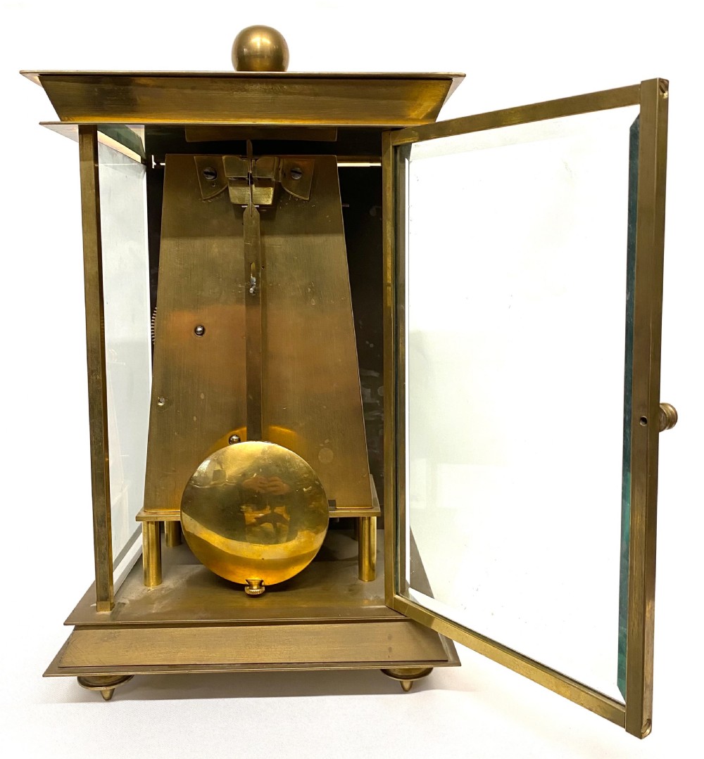 An antique brass four-glass library clock featuring an engraved silvered dial with Roman numerals and glass side panels. View VII