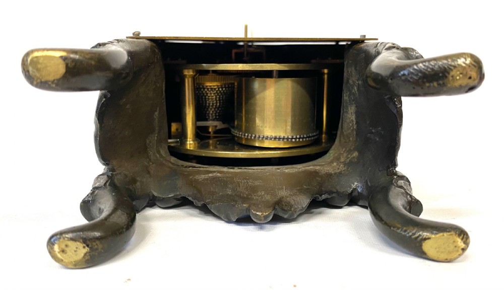 An antique miniature bronze mantel clock featuring Rococo scrollwork, cabriole legs, and an engraved gold-tone brass dial with Roman numerals. View VI