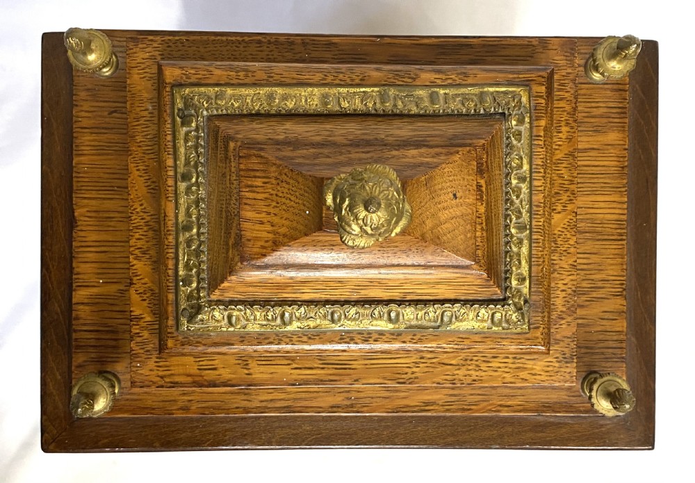 An antique oak double fusee mantel clock with brass caryatid corner mounts, brass finials, an engraved metal dial with Roman numerals, and brass bracket feet. View X