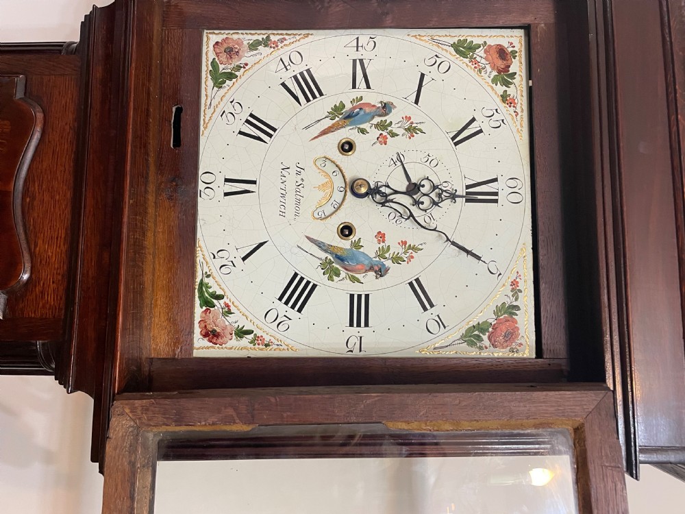 An antique oak and mahogany longcase grandfather clock featuring three brass ball finials, a hand-painted dial face, and fluted column details. View VIII