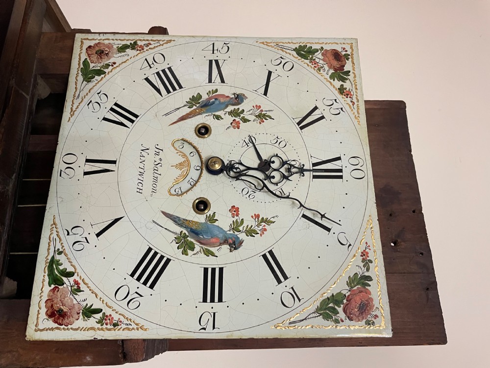 An antique oak and mahogany longcase grandfather clock featuring three brass ball finials, a hand-painted dial face, and fluted column details. View XI