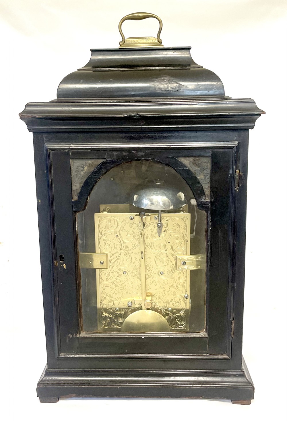 An 18th-century ebonised wooden bracket clock featuring a brass dial with silvered chapter rings, decorative corner spandrels, a strike/silent sub-dial, and a brass carrying handle on top. View XIV