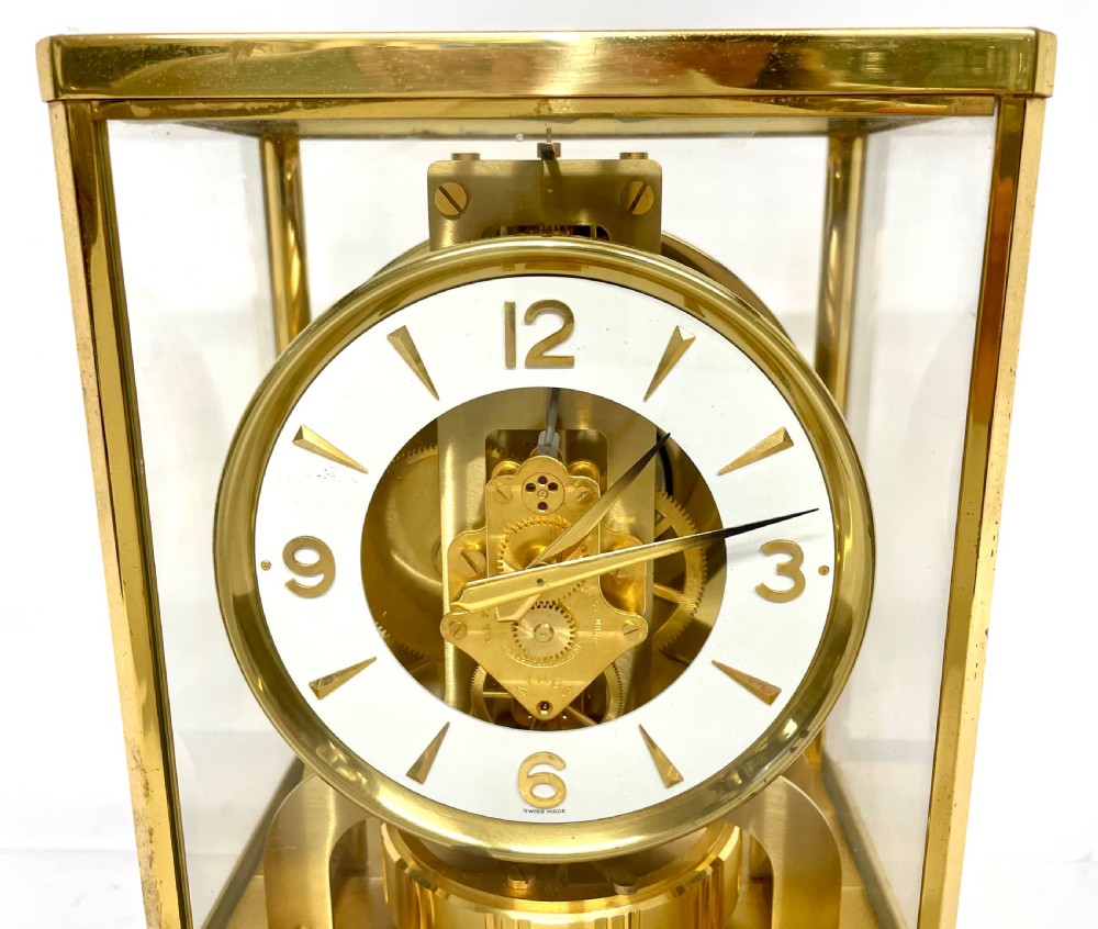 A mid-twentieth-century Jaeger-LeCoultre Atmos clock featuring a rectangular gilt brass frame with glass side panels exposing the mechanical movement and white dial. View IV