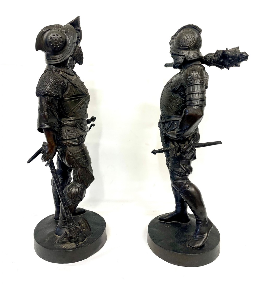 A pair of dark patinated Victorian bronze figures depicting armoured cavalier soldiers standing on circular bases. View VI