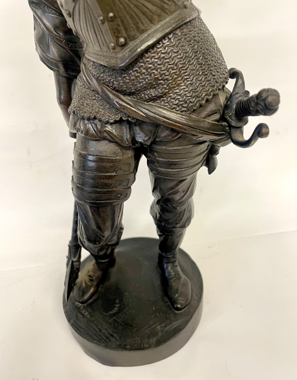 A pair of dark patinated Victorian bronze figures depicting armoured cavalier soldiers standing on circular bases. View X