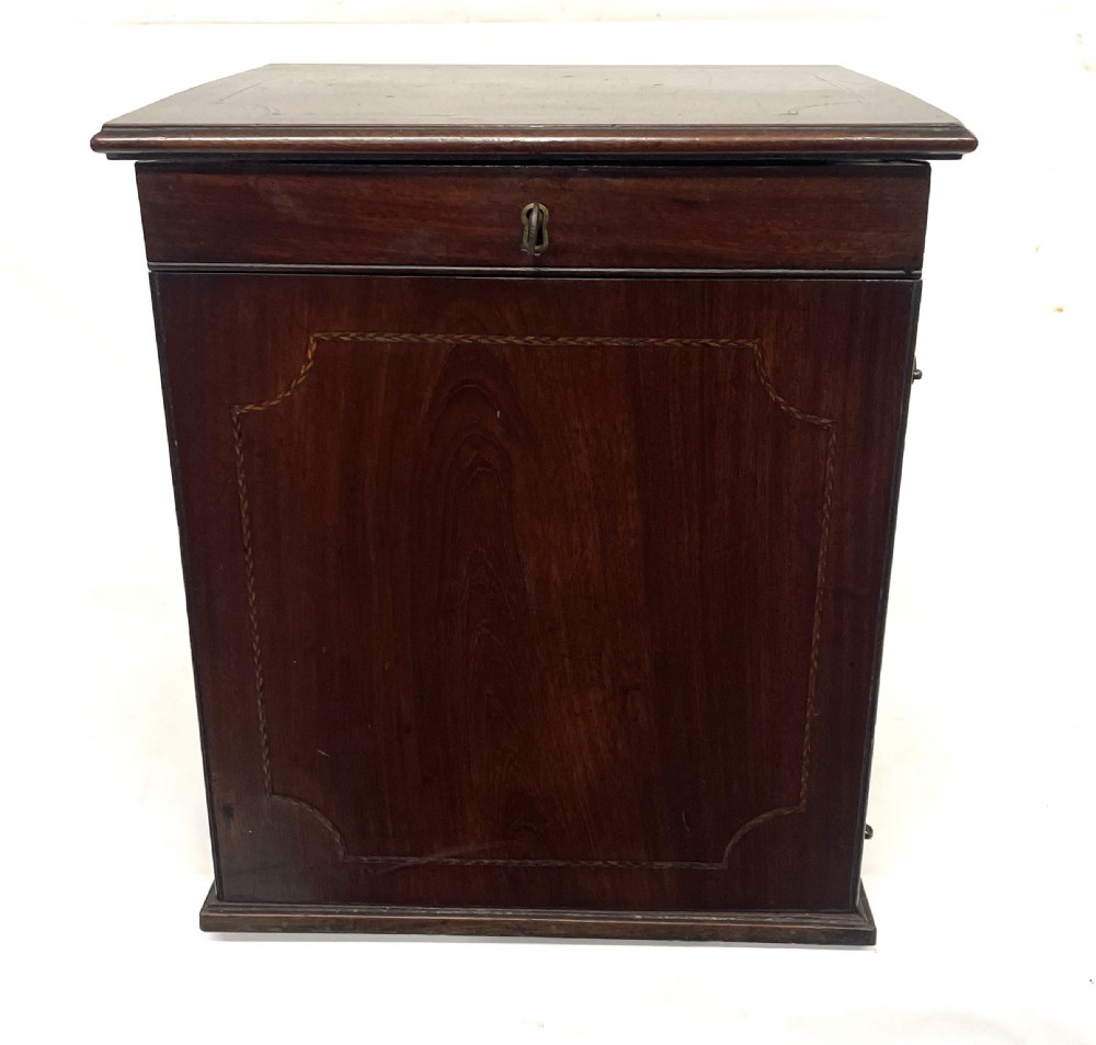 A Georgian dark mahogany apothecary chest with an open hinged lid revealing glass stoppered bottles, a side-hinged door, and interior drawers with brass handles. View IV