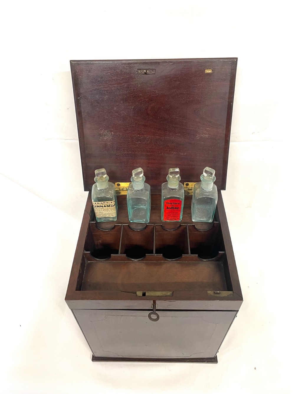 A Georgian dark mahogany apothecary chest with an open hinged lid revealing glass stoppered bottles, a side-hinged door, and interior drawers with brass handles. View XIII
