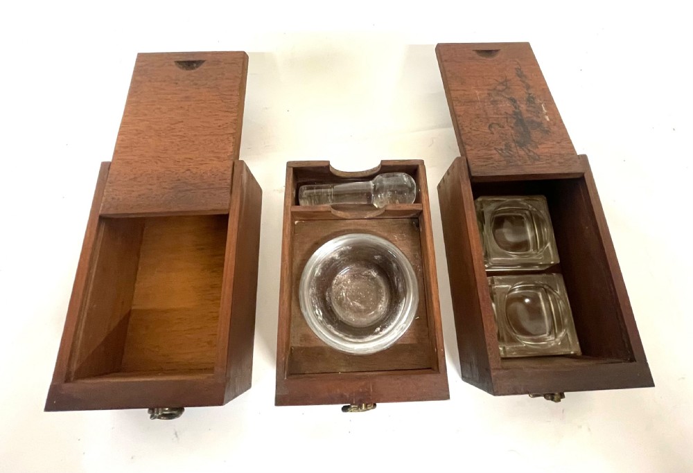 A Georgian dark mahogany apothecary chest with an open hinged lid revealing glass stoppered bottles, a side-hinged door, and interior drawers with brass handles. View XVIII
