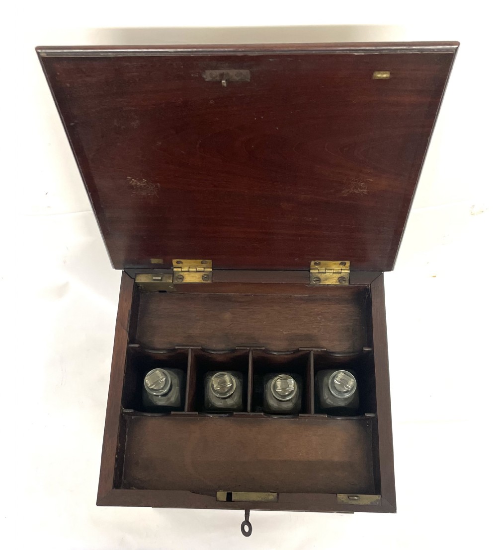 A Georgian dark mahogany apothecary chest with an open hinged lid revealing glass stoppered bottles, a side-hinged door, and interior drawers with brass handles. View XXIII