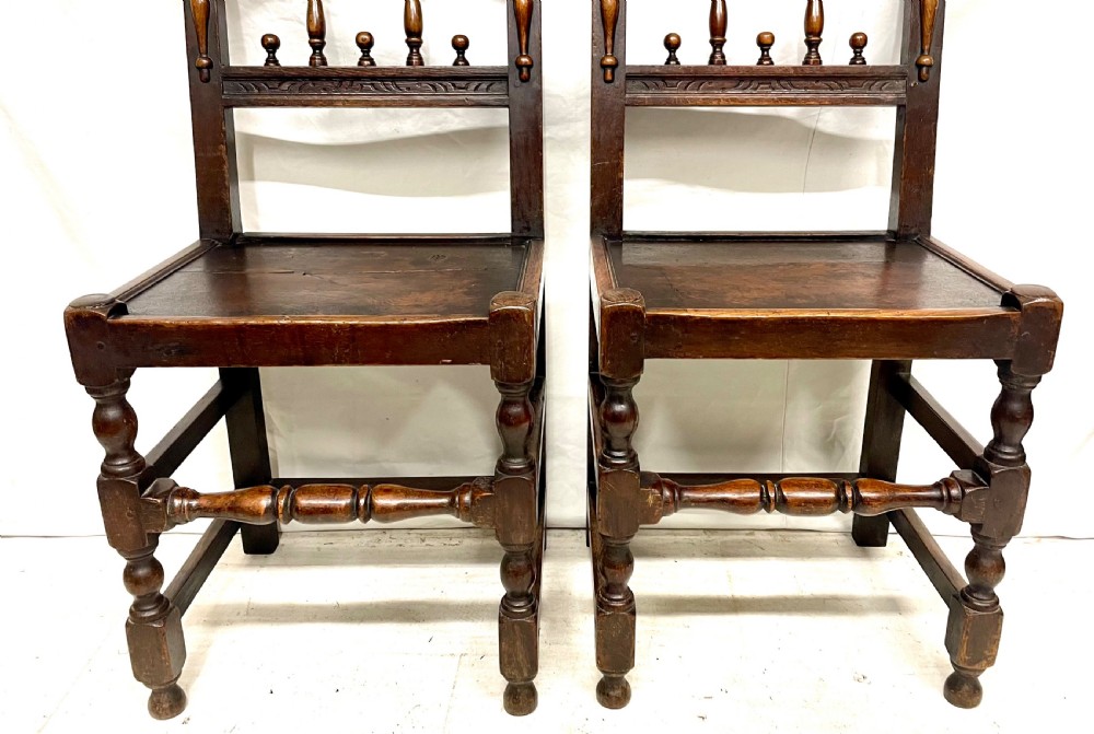 Set of four dark oak dining chairs featuring arcaded carved backs with turned spindles, scroll crestings, and solid plank seats. View XII