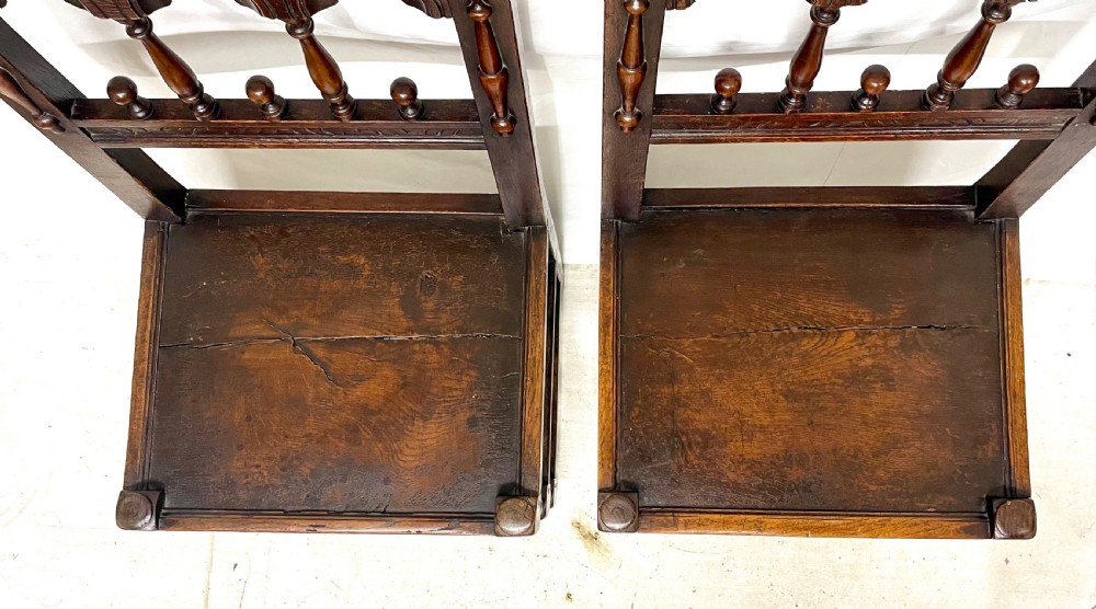Set of four dark oak dining chairs featuring arcaded carved backs with turned spindles, scroll crestings, and solid plank seats. View XIV
