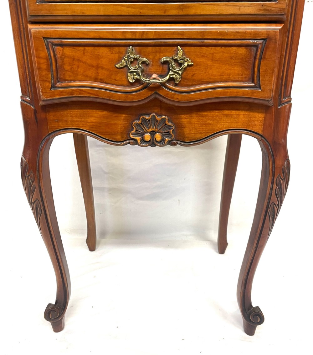 A pair of French satin walnut bedside cabinets featuring three drawers with brass handles, carved shell details on the apron, and slender cabriole legs. View XI