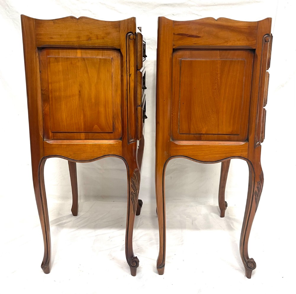 A pair of French satin walnut bedside cabinets featuring three drawers with brass handles, carved shell details on the apron, and slender cabriole legs. View XVIII