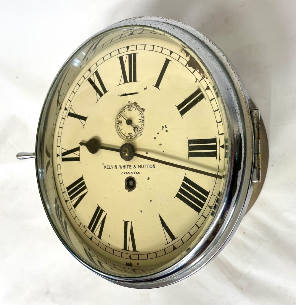 An antique circular nickel-plated brass ships bulkhead clock featuring a cream dial with Roman numerals and a subsidiary seconds dial. View III