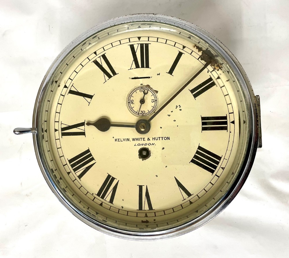 An antique circular nickel-plated brass ships bulkhead clock featuring a cream dial with Roman numerals and a subsidiary seconds dial. View XIX
