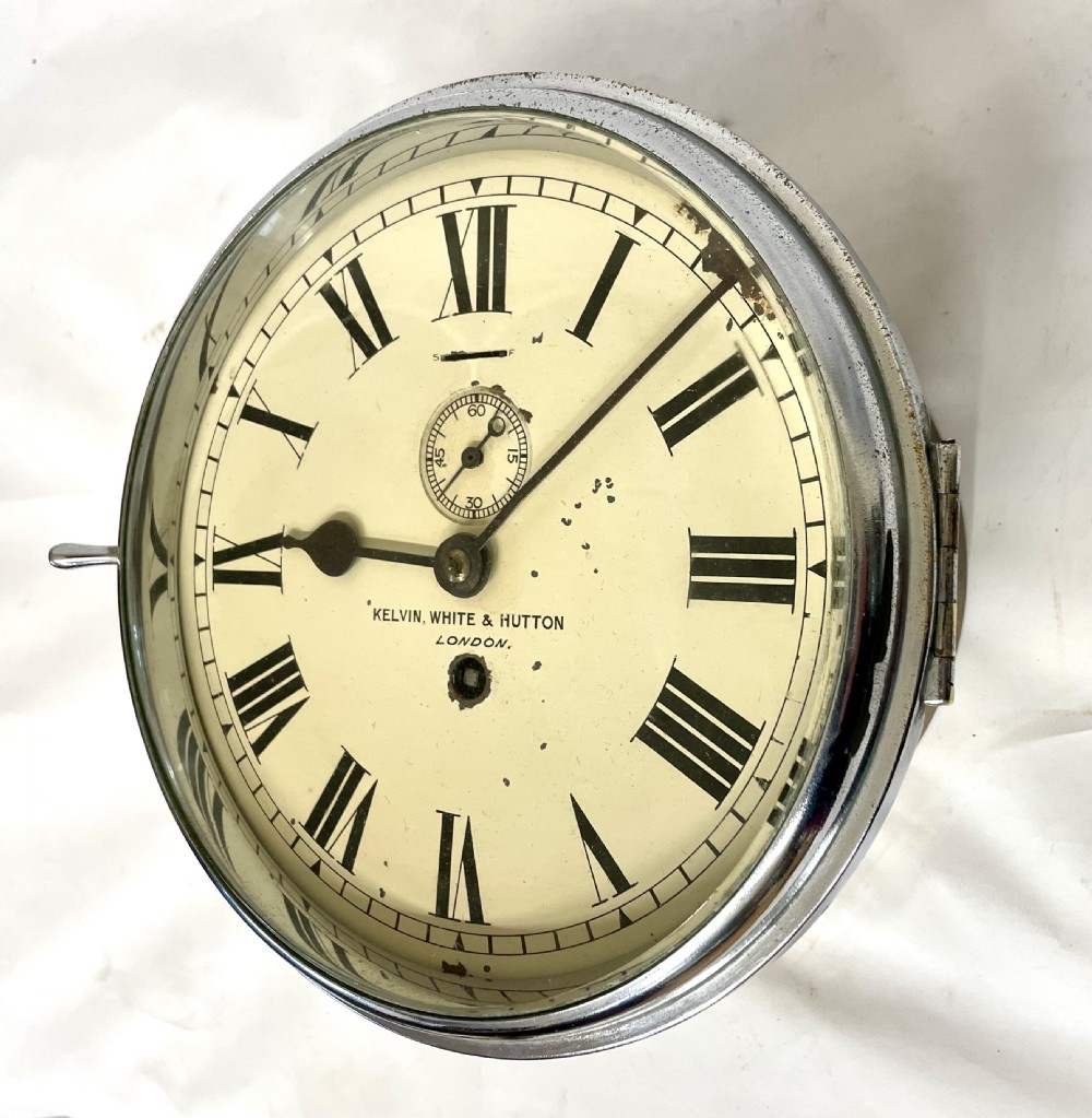An antique circular nickel-plated brass ships bulkhead clock featuring a cream dial with Roman numerals and a subsidiary seconds dial. View XX