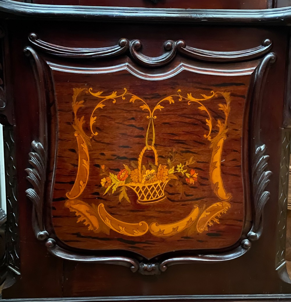 An antique Chippendale Revival mahogany longcase clock featuring a carved swan-neck pediment, floral marquetry, and a brass dial behind a glazed door. View VIII