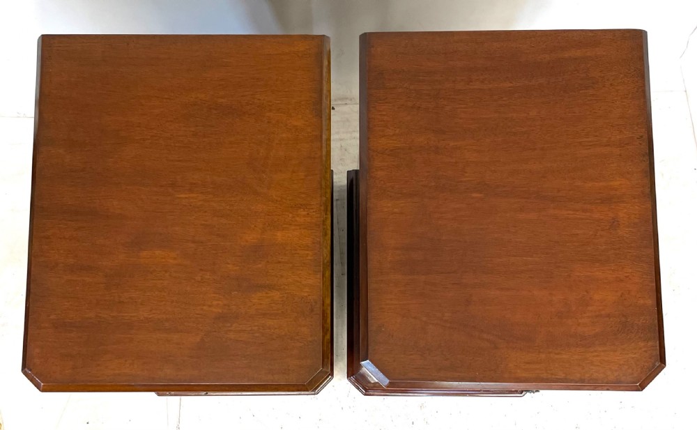 A pair of Victorian mahogany bedside cabinets featuring top drawers, panelled cupboard doors with metal handles, and solid plinth bases. View VI