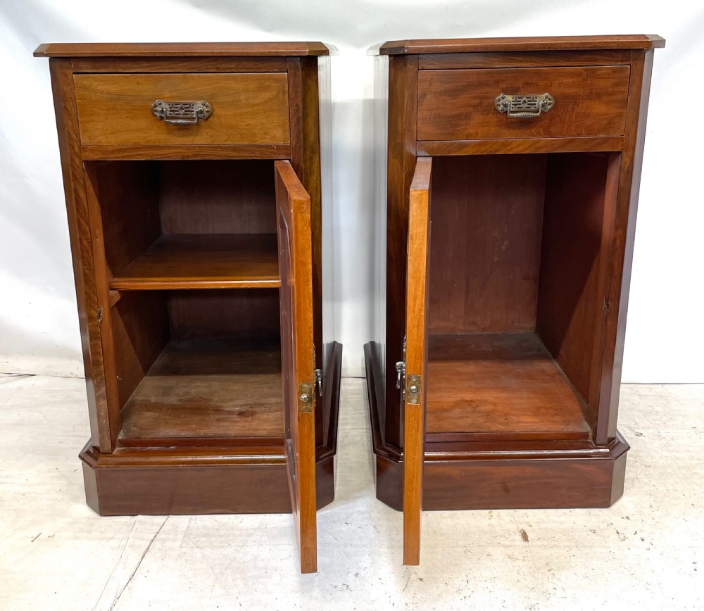 A pair of Victorian mahogany bedside cabinets featuring top drawers, panelled cupboard doors with metal handles, and solid plinth bases. View IX