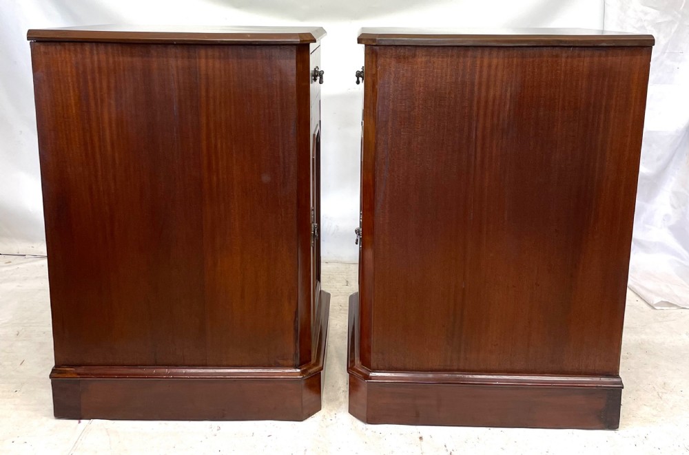 A pair of Victorian mahogany bedside cabinets featuring top drawers, panelled cupboard doors with metal handles, and solid plinth bases. View XI