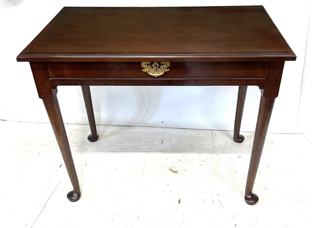 An antique Georgian mahogany side table featuring a rectangular top with a moulded rim, a single drawer with brass hardware, and slender cabriole legs ending in pad feet. View IV