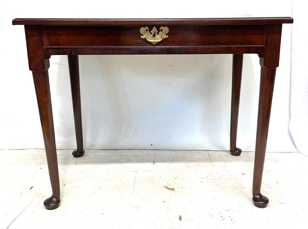 An antique Georgian mahogany side table featuring a rectangular top with a moulded rim, a single drawer with brass hardware, and slender cabriole legs ending in pad feet. View VI